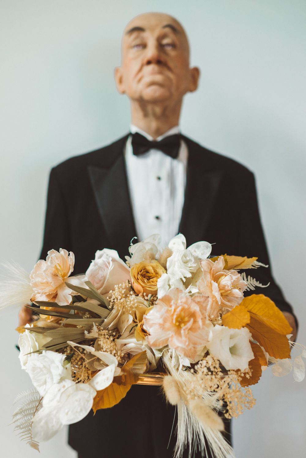 Elegant floral arrangement with white and yellow blooms against light background.