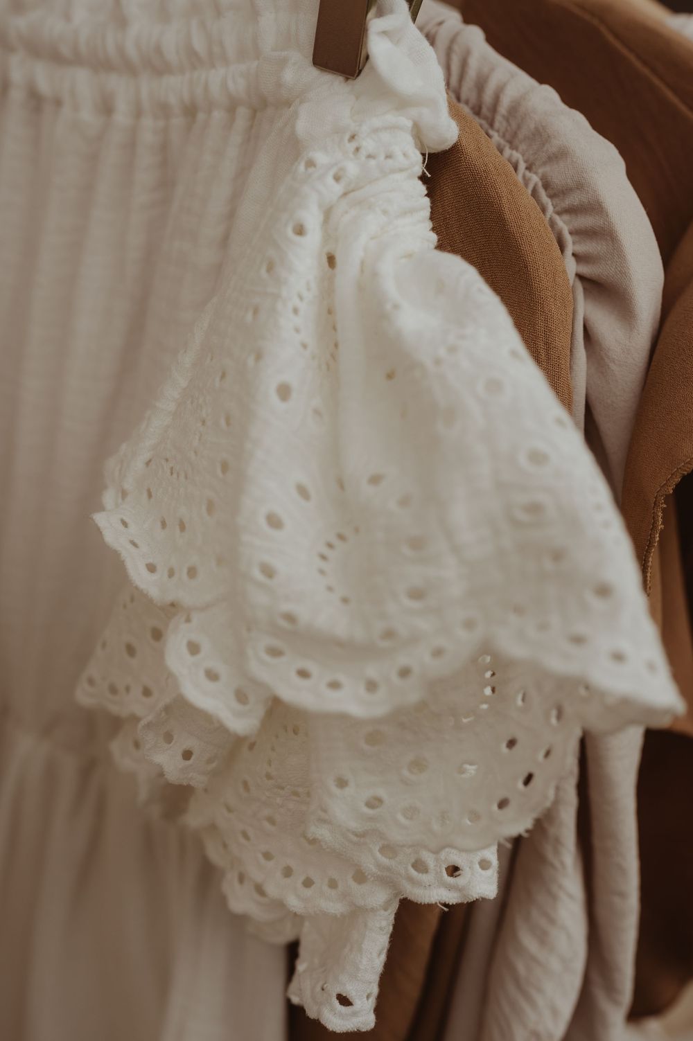 Close-up van fijne witte broderie met geschulpte randen en verfijnde geborduurde details