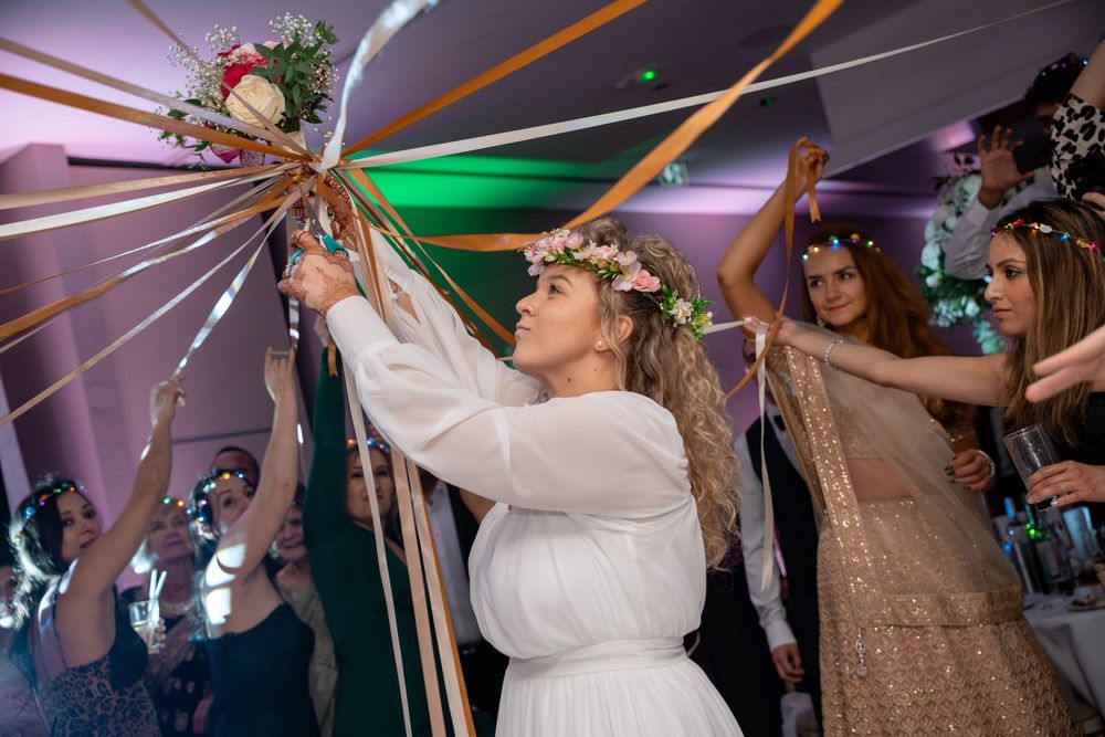 Wedding reception dance party with colorful lighting and guests celebrating.