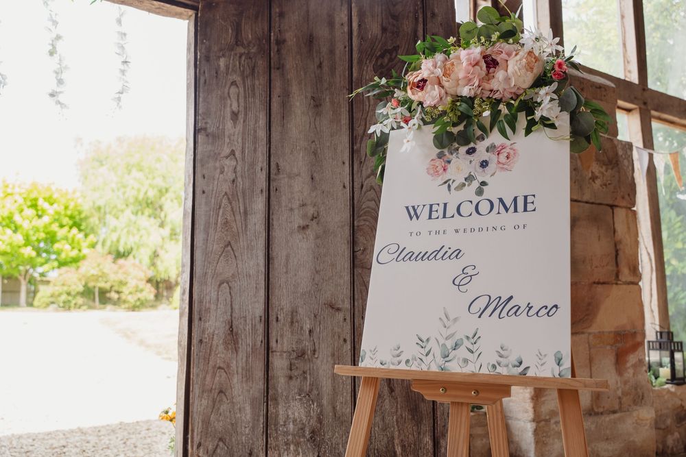 Rustic wooden wedding welcome signs and decor displayed at venue entrance.