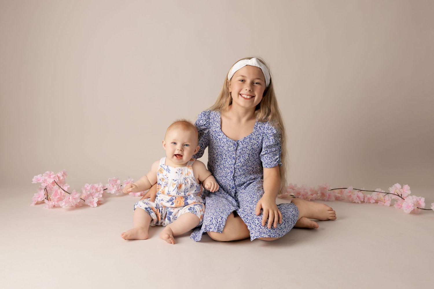 A progression of five connected images showing a baby and parent sitting on a beige backdrop with pink accents.