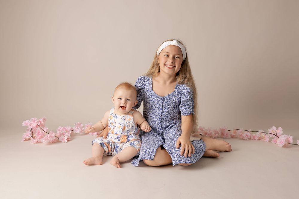 A progression of five connected images showing a baby and parent sitting on a beige backdrop with pink accents.