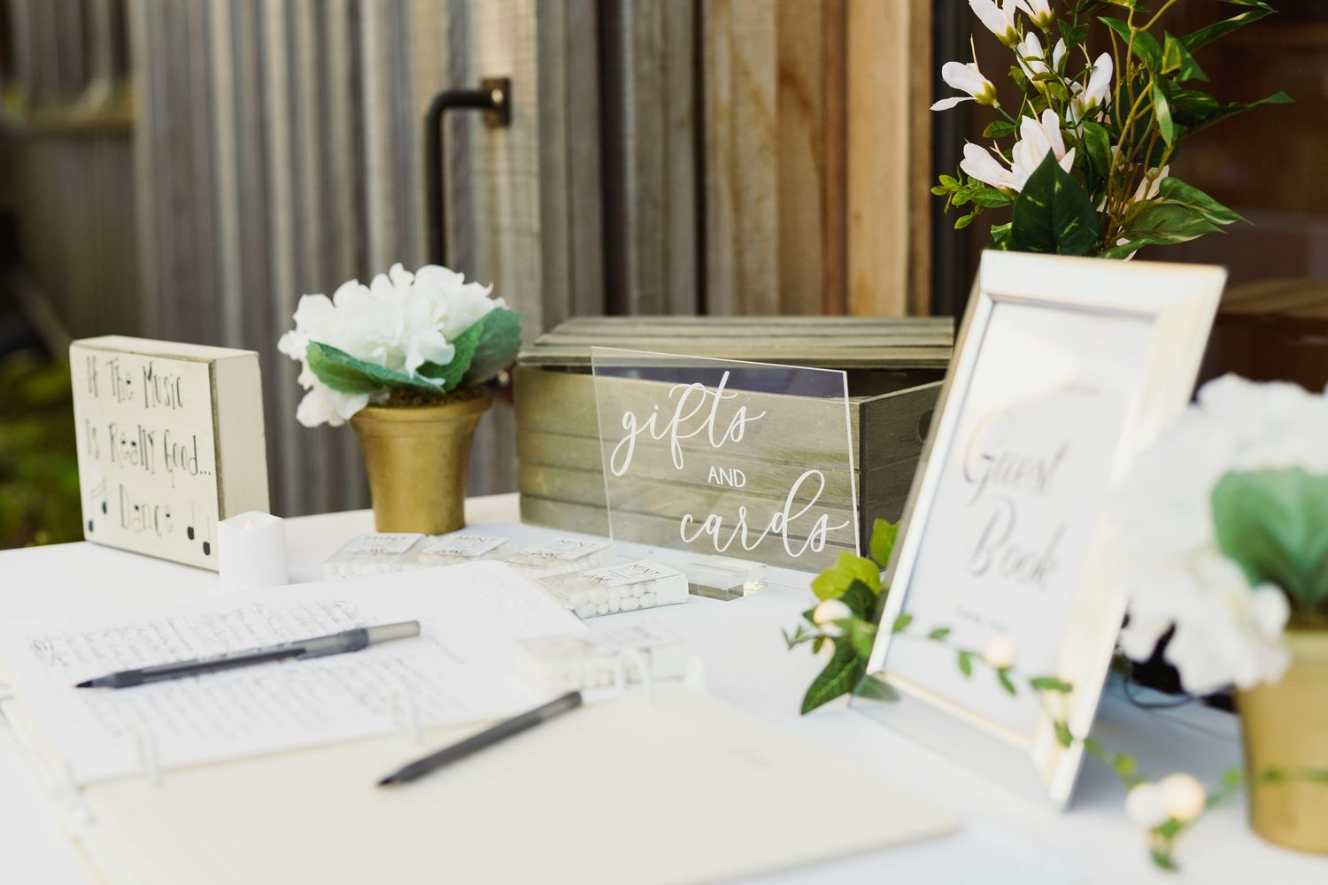 Wedding reception table settings with white floral arrangements and elegant place cards.