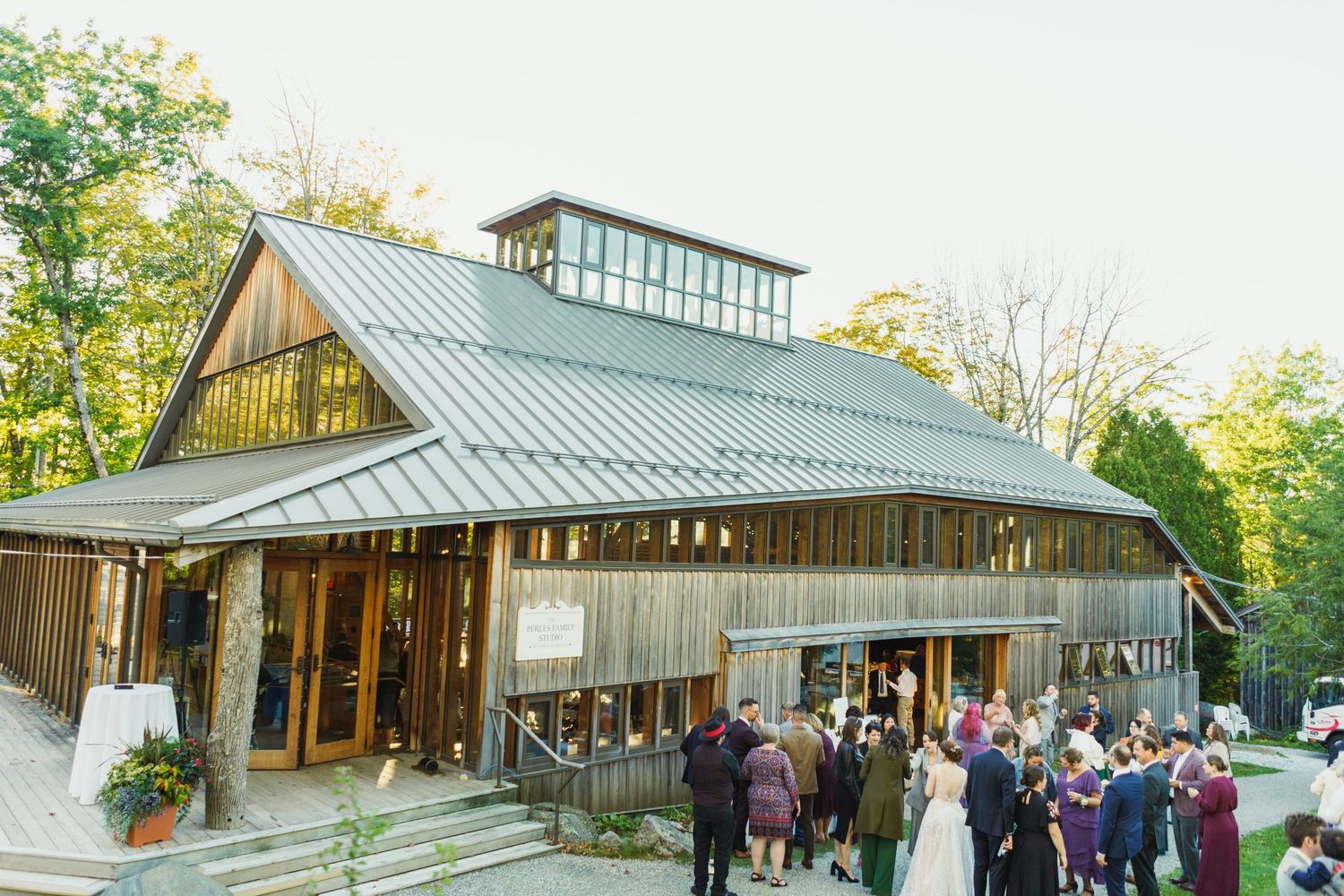 Modern rustic wedding venue exterior with wooden architecture and glass windows.
