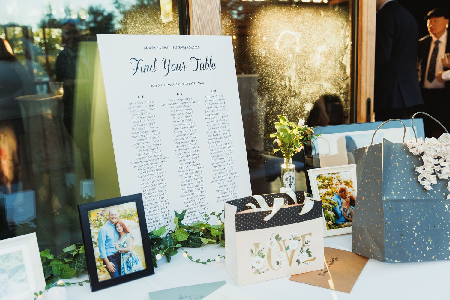 Wedding reception decor featuring table assignment displays and photo arrangements.
