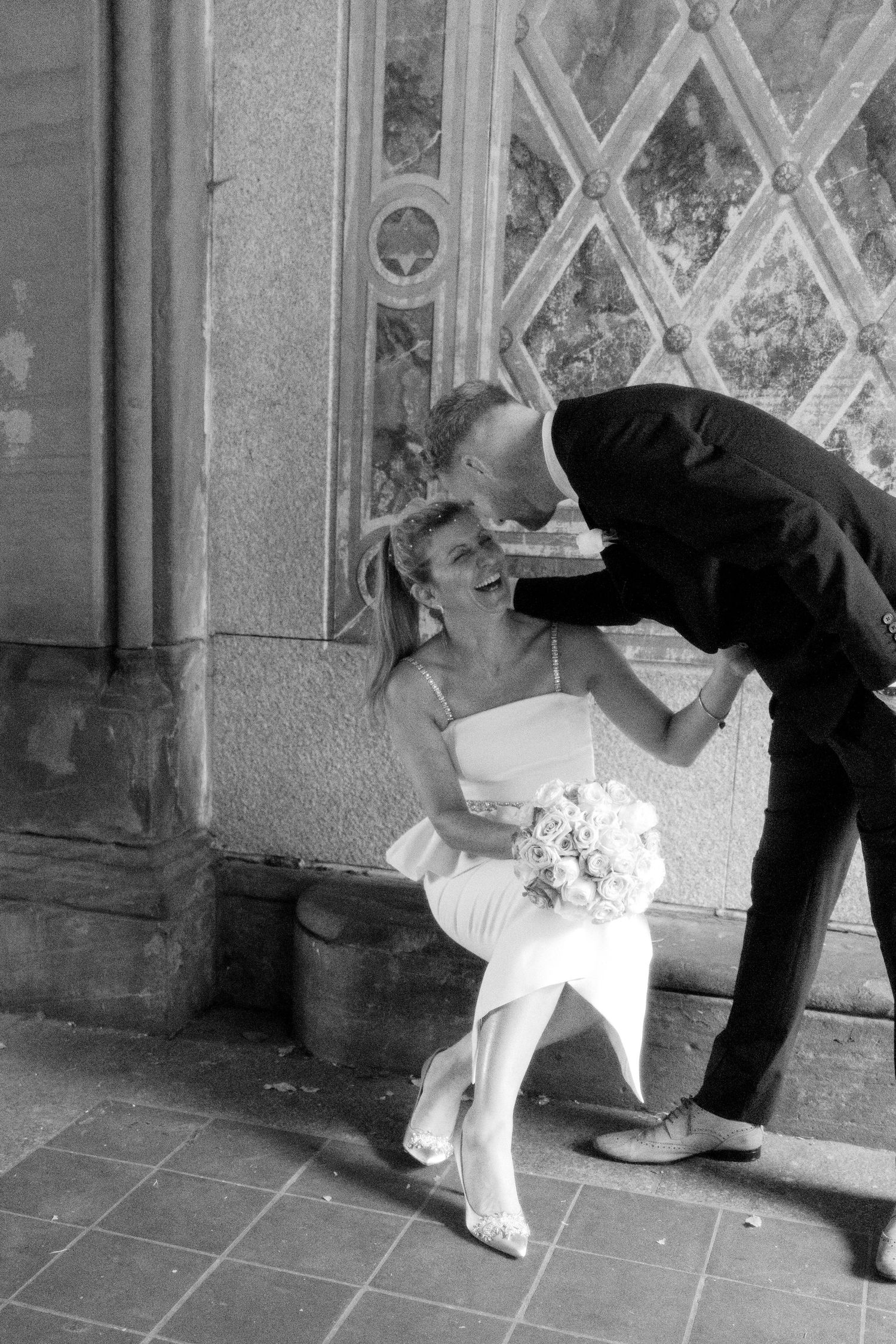 Black and white sequence showing playful wedding couple posing near ornate doorway.