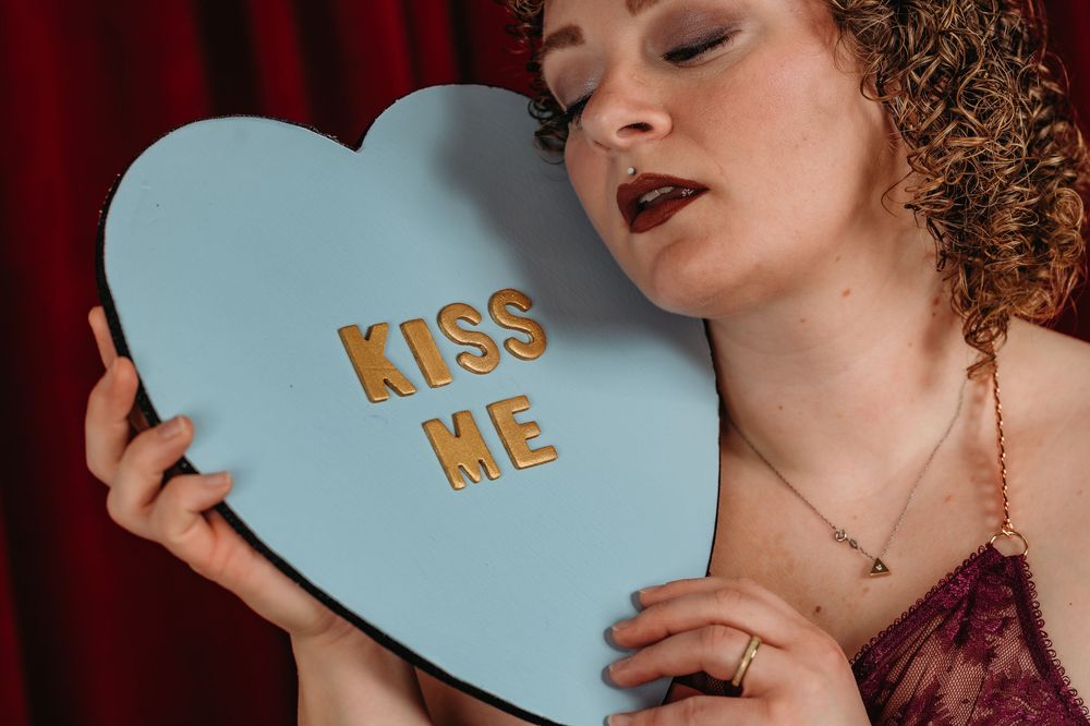 Romantic portrait series featuring light blue conversation heart props with text against burgundy backdrop.