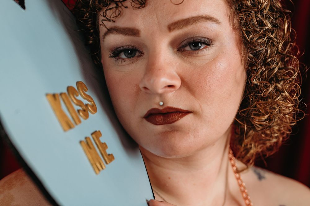 Artistic cropped portrait shots showing curly hair and dramatic makeup in blue lighting.