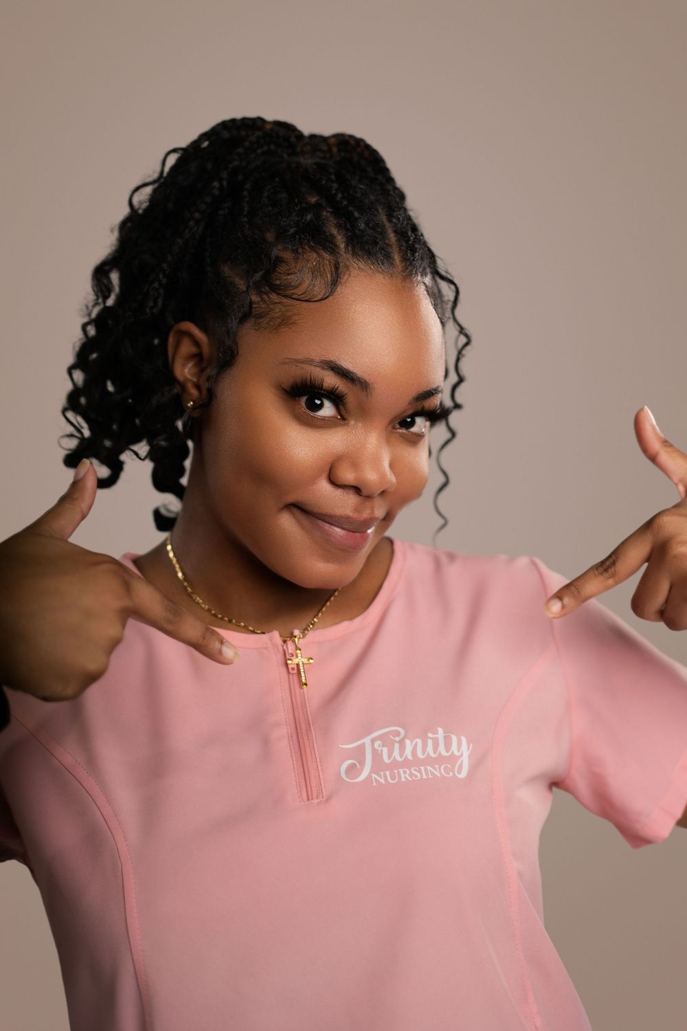 Person wearing a pink sweatshirt poses playfully against a neutral background in a photo series.