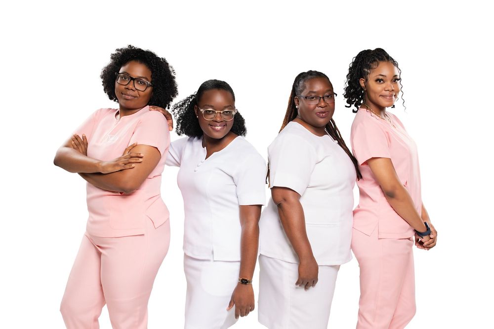 A group of women wearing pink and white outfits stand together in a row showing unity and support.