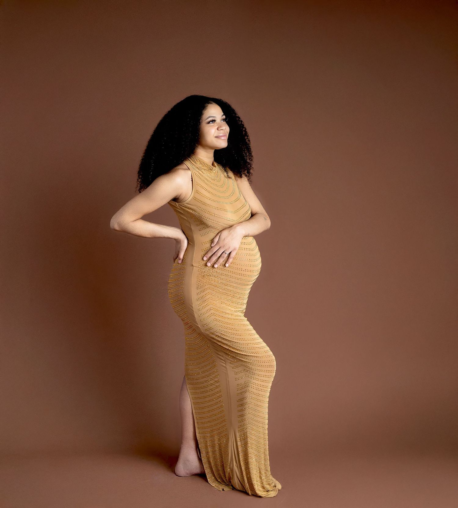 A beige knit dress hangs on a wooden wall-mounted coat rack in a hallway corner.