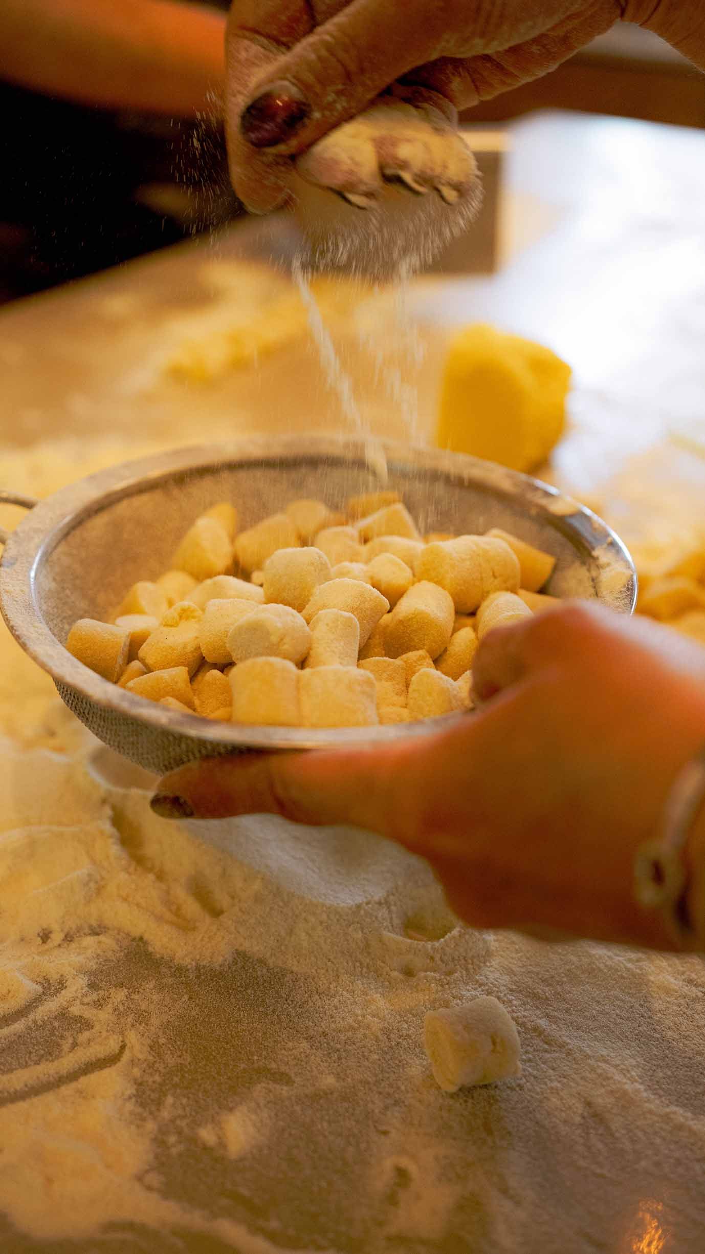 Mano che setaccia una pasta per togliere farina in eccesso, mirko paoloni videomaker