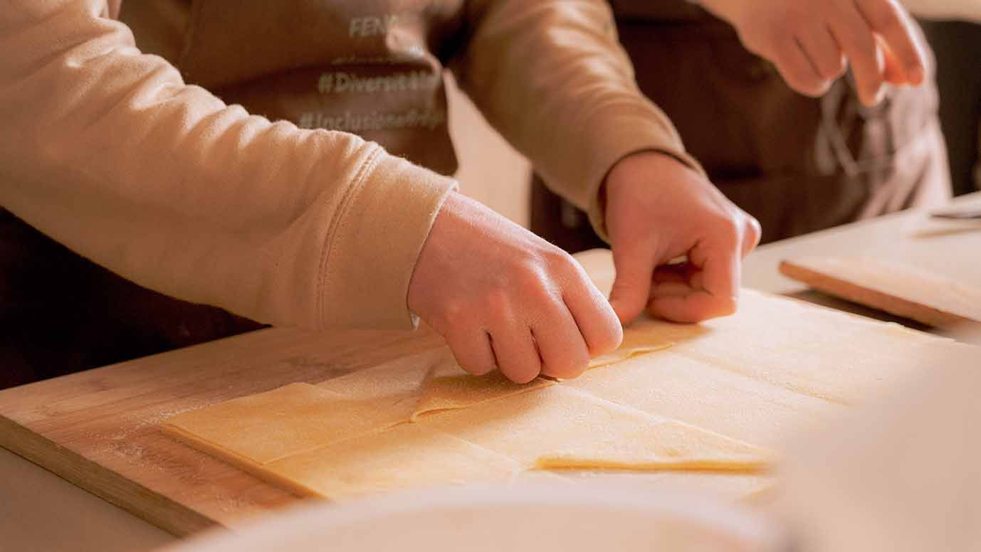 Mani che impastano la pasta