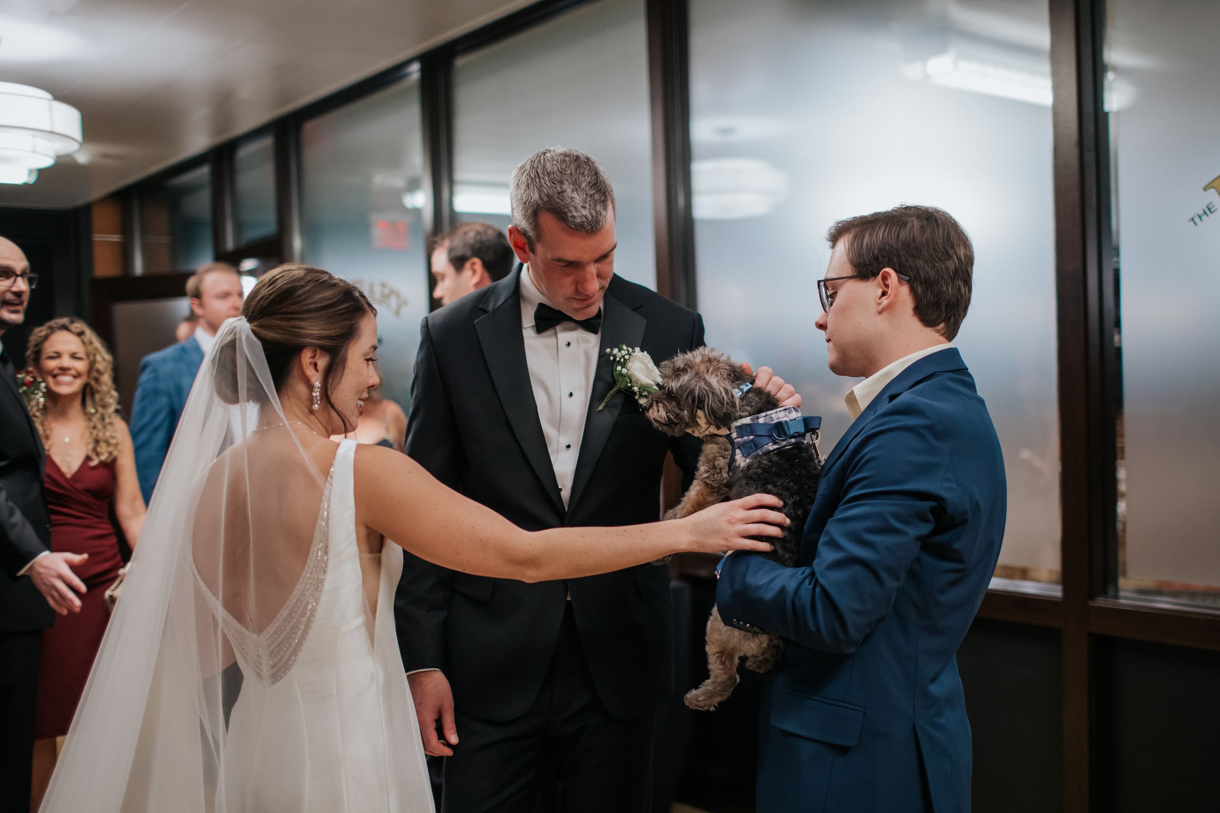 A couple shares a tender moment with their dog during their wedding ceremony.