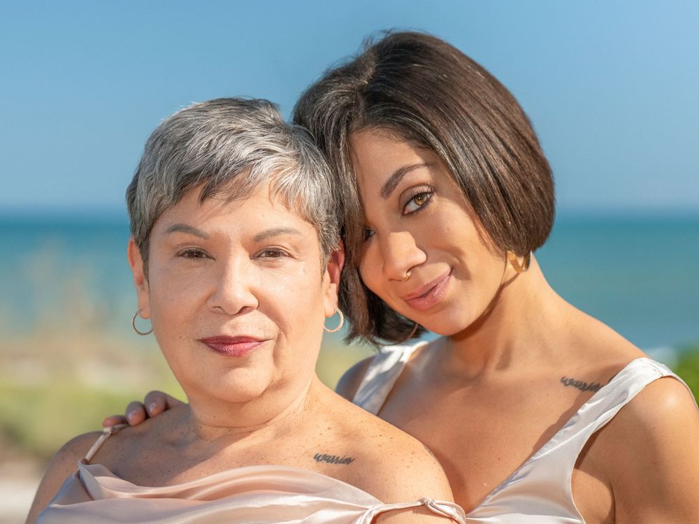 Two people share a joyful embrace while enjoying a sunny day at the beach.
