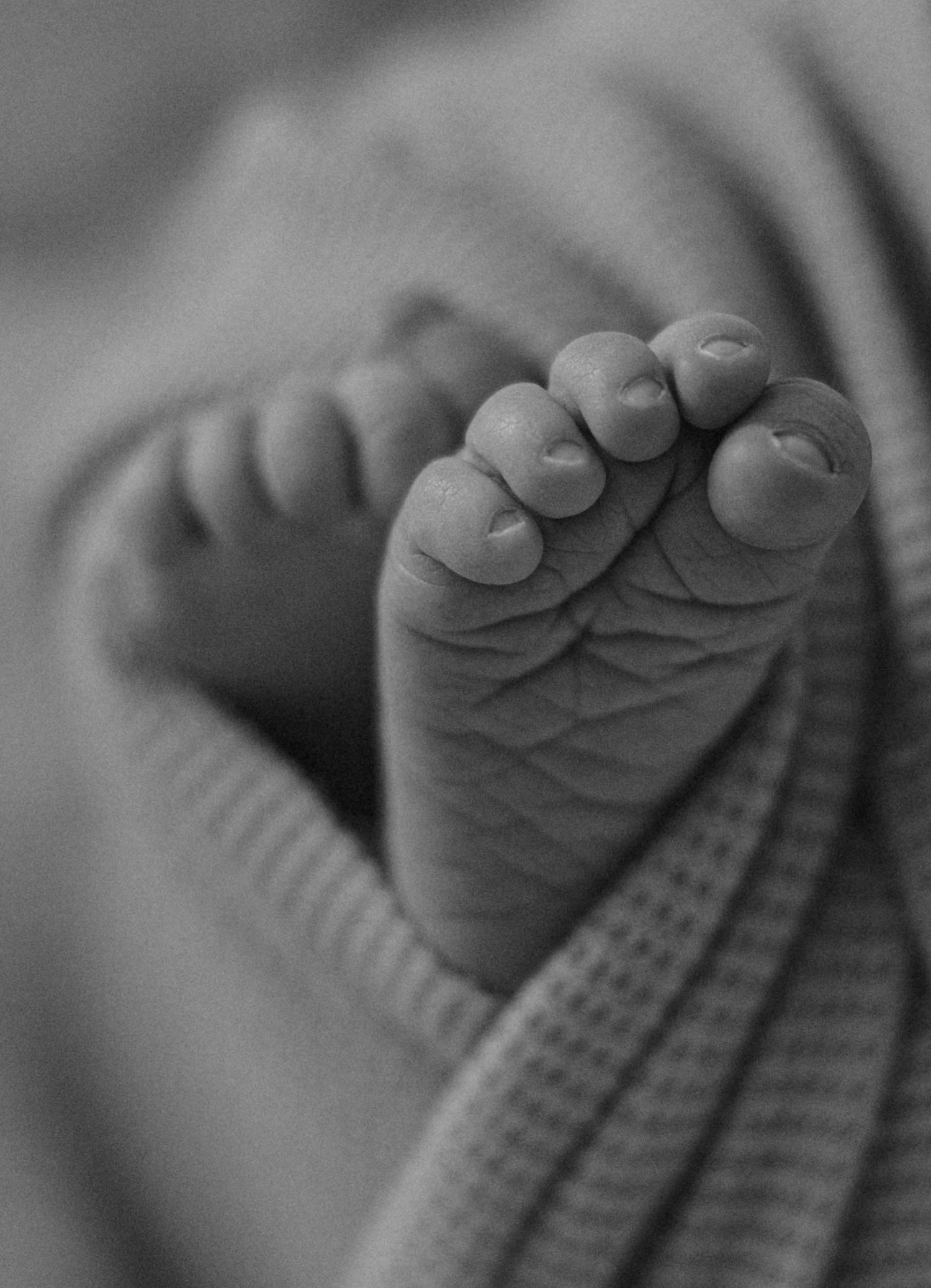Father holding his newborn baby close during a lifestyle newborn photography session in soft natural light.