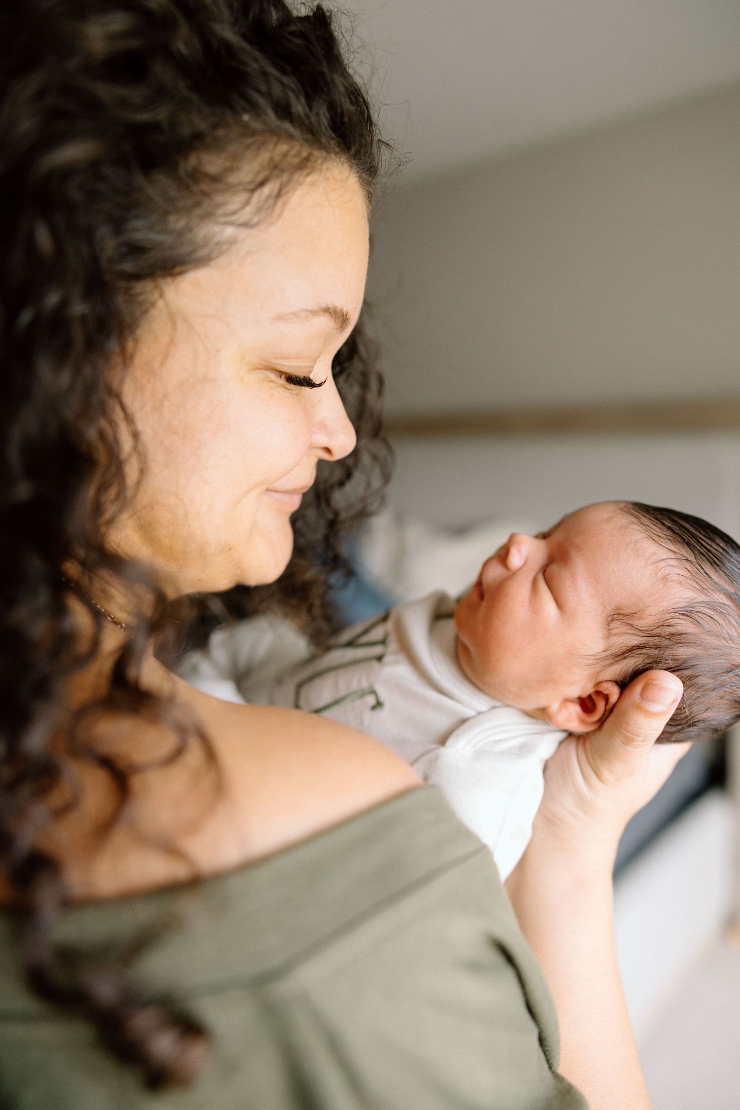 Mother gazing at her newborn baby during a lifestyle session.