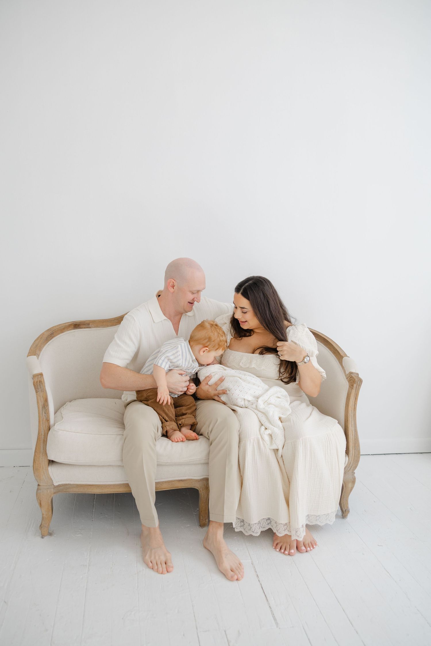 Mother holding her newborn baby close during a soft, light-filled lifestyle newborn photography session.