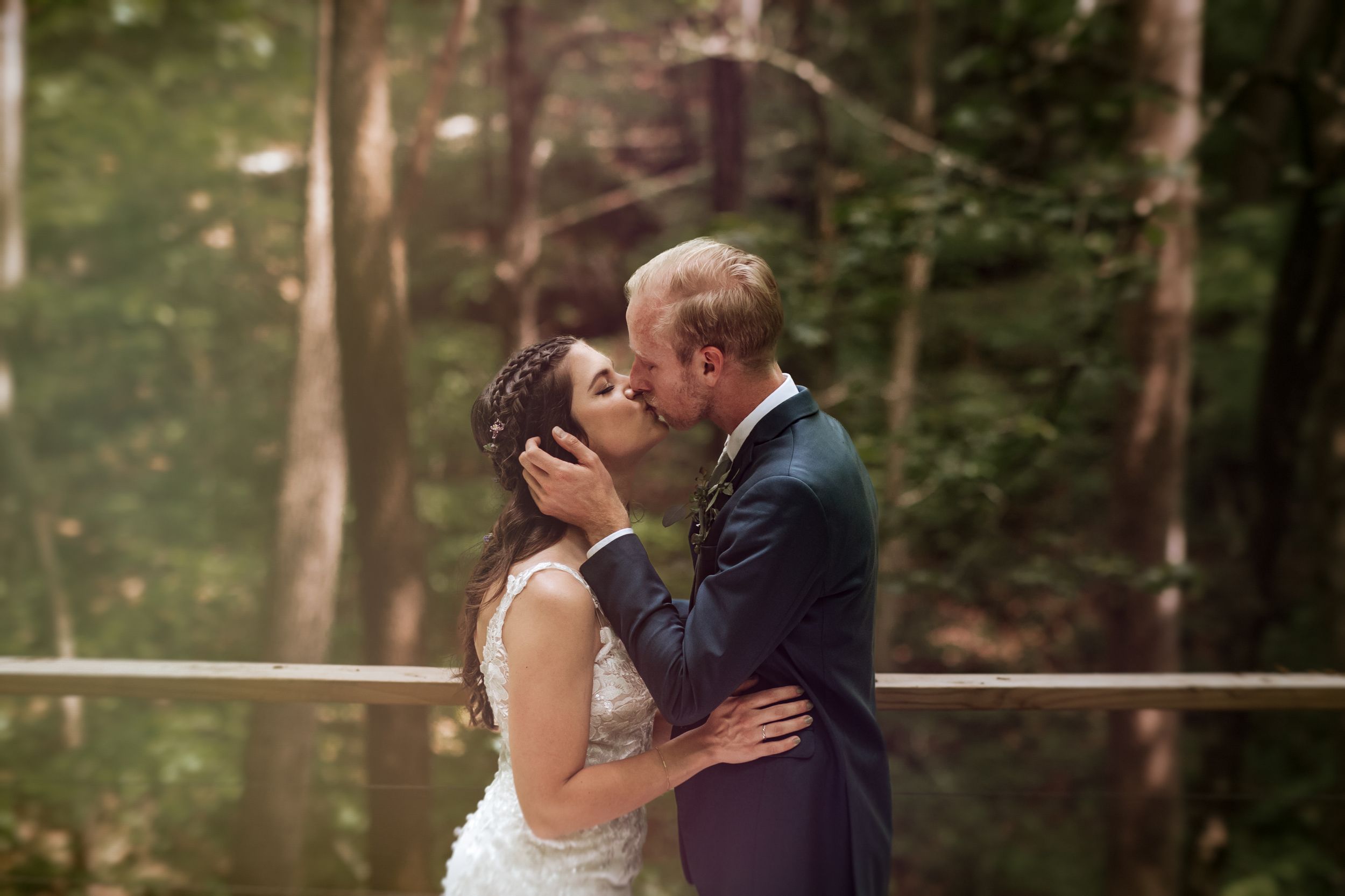 Romantic moment captured during an outdoor forest wedding ceremony.