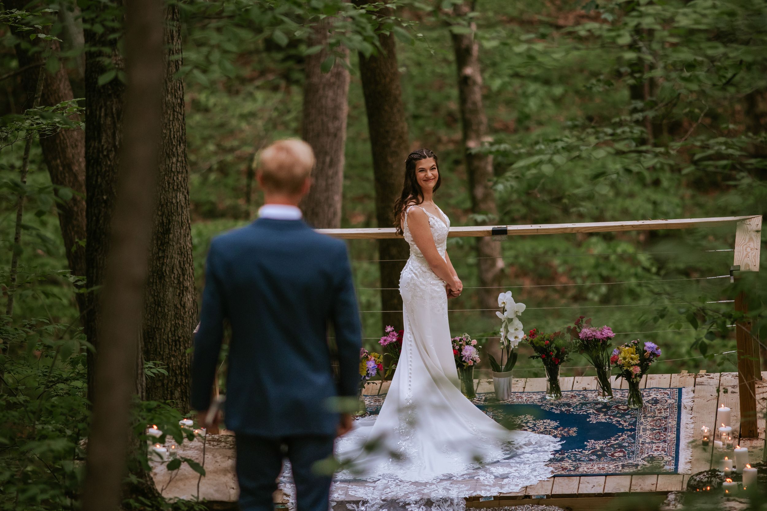 Wedding ceremony setup in a serene forest setting with wooden benches and natural decor.