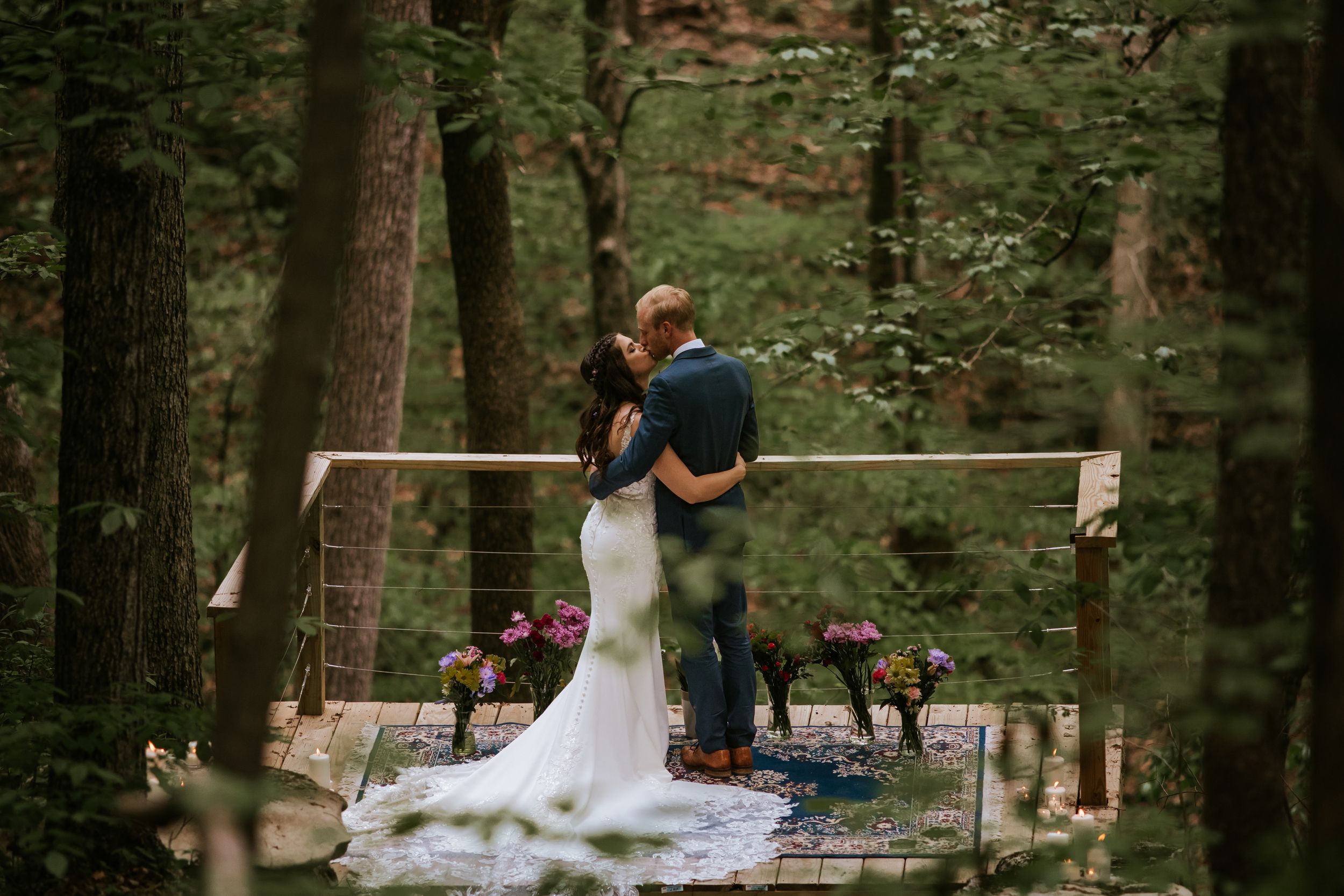 Intimate woodland wedding ceremony with natural light filtering through the trees.