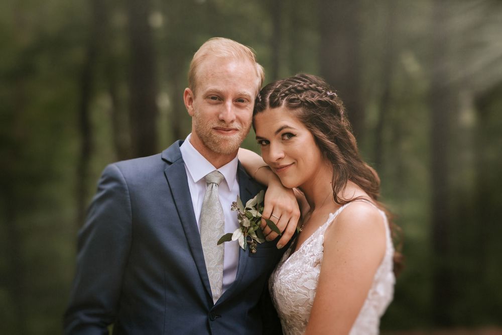 Romantic wedding portraits captured in a lush green forest setting.