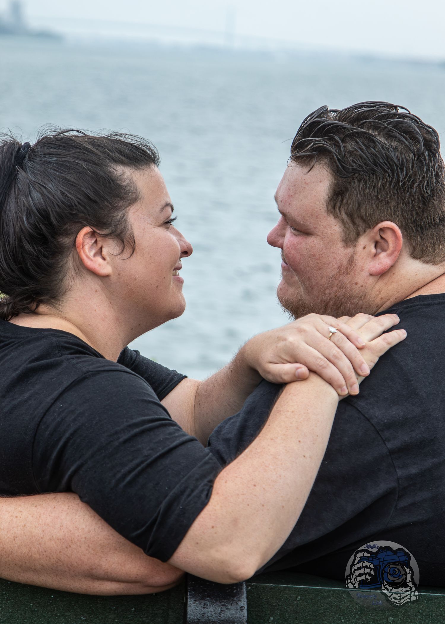 A couple dances together during golden hour in a romantic outdoor setting with autumn foliage in the background.