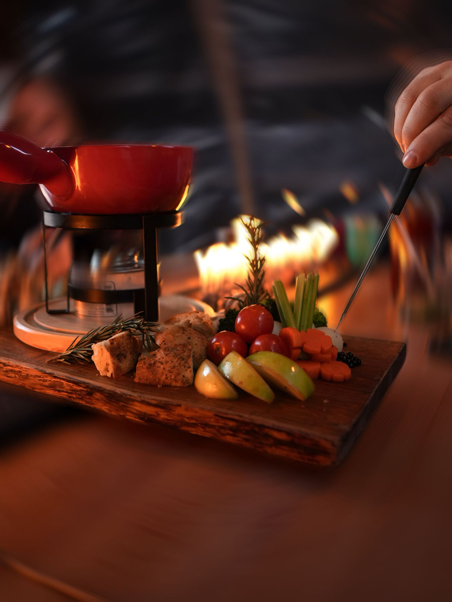 A rustic wooden serving board displays an assortment of colorful appetizers lit by warm ambient lighting.