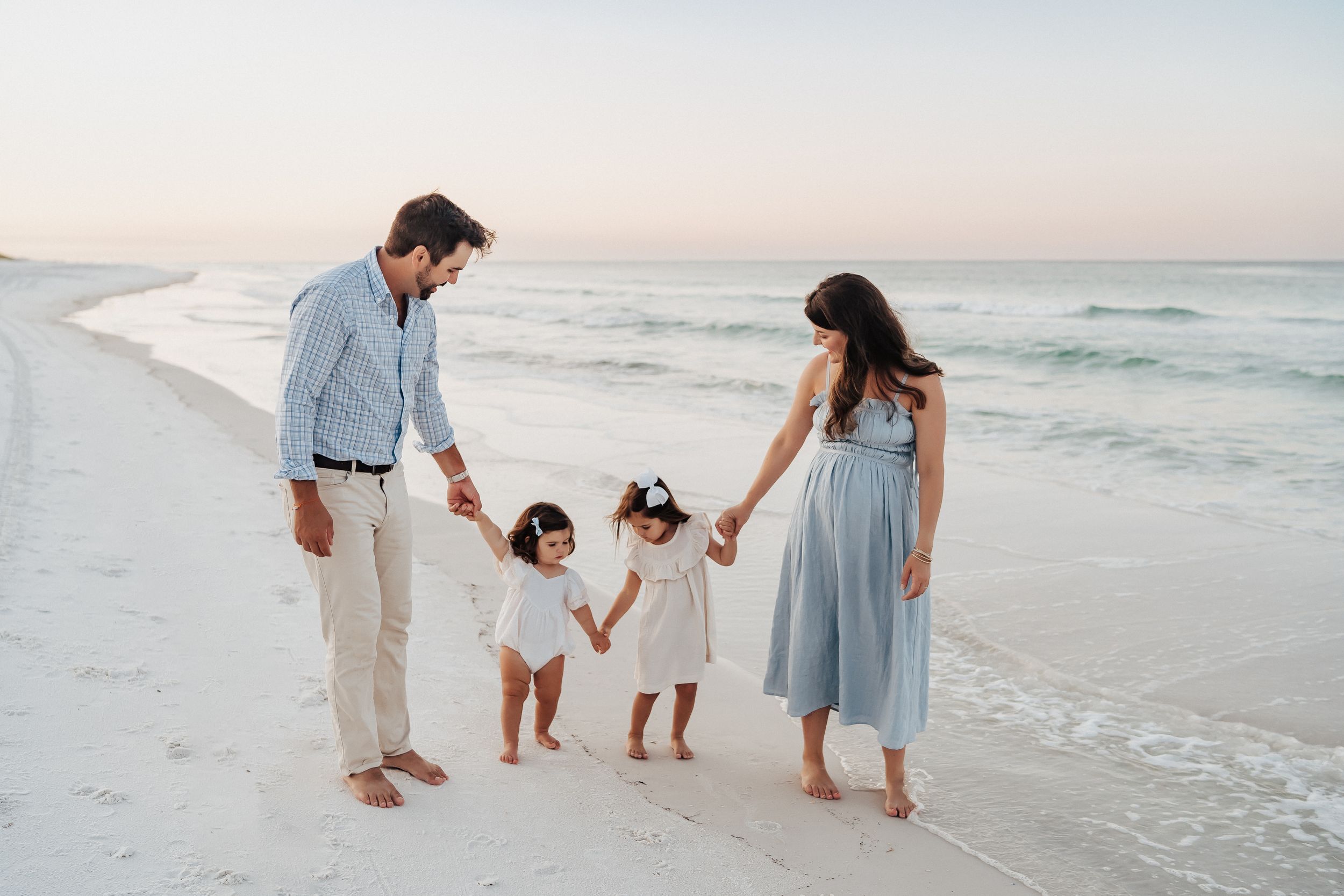 Sunrise family photo session on 30A beach with soft pastel sky