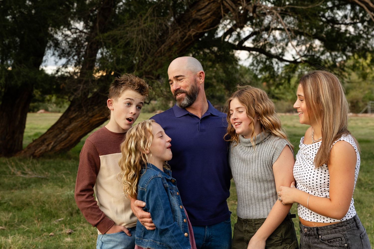 dad laughing with 4 kids looking at each other