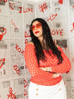 Artistic photo series against newspaper wall with red heart graffiti showing polka dot dress and dramatic poses.