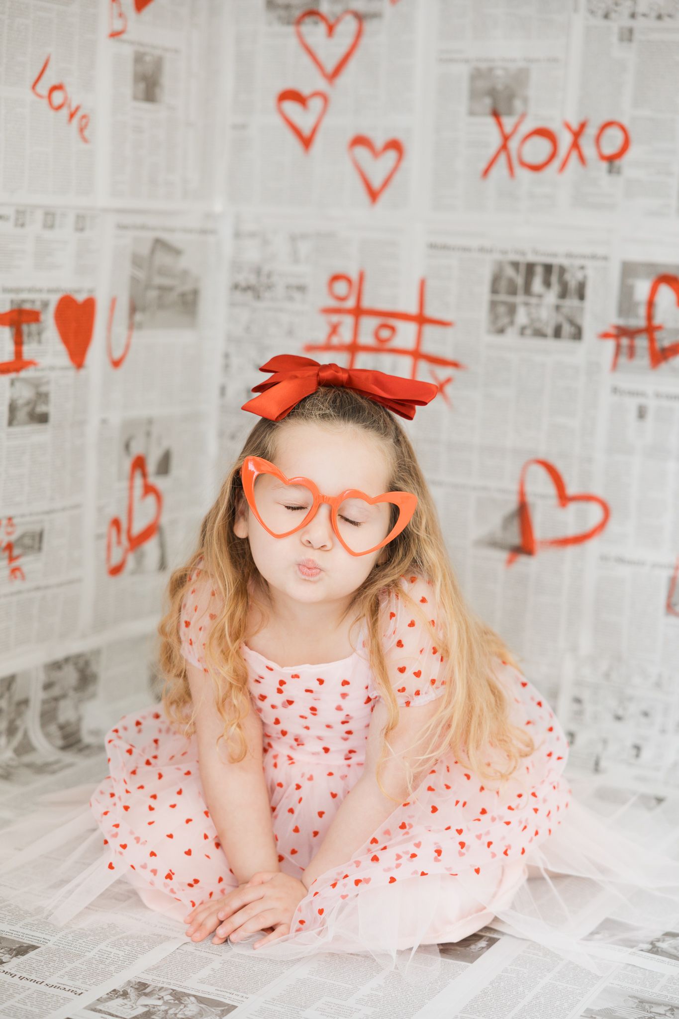 Creative photo series with orange accessories and heart doodles on newspaper background showing fun expressions.