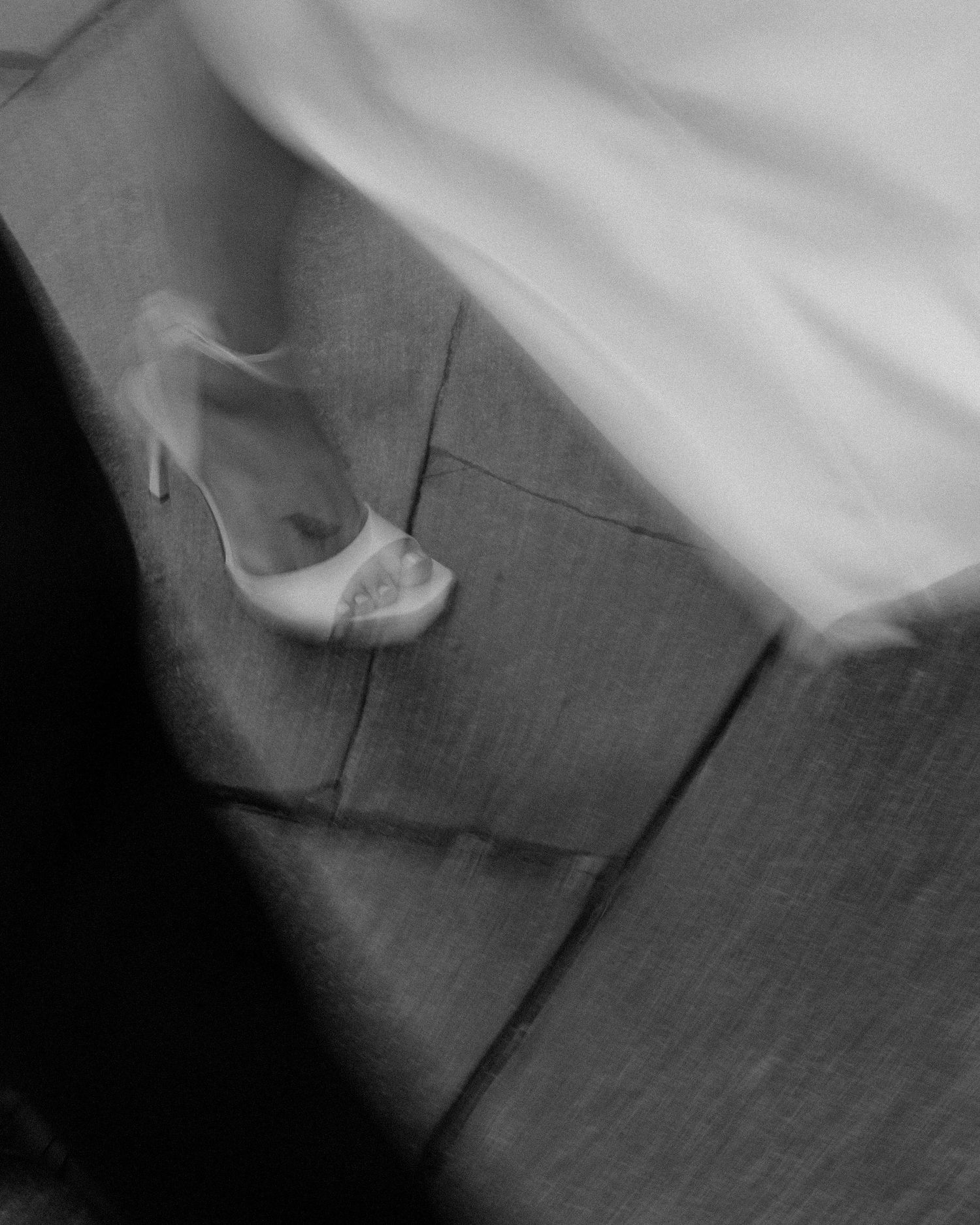 Abstract black and white close-up shots of wedding dress details and shoes.