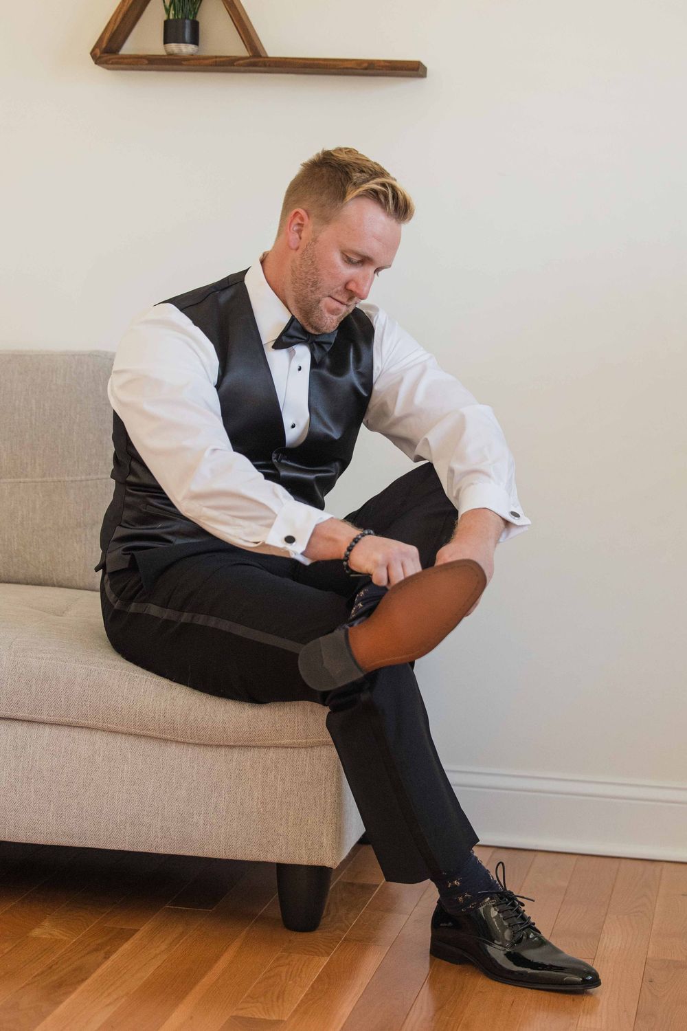 Evan puts on his shoes prior to his wedding at a private home in Point Pleasant, NJ.