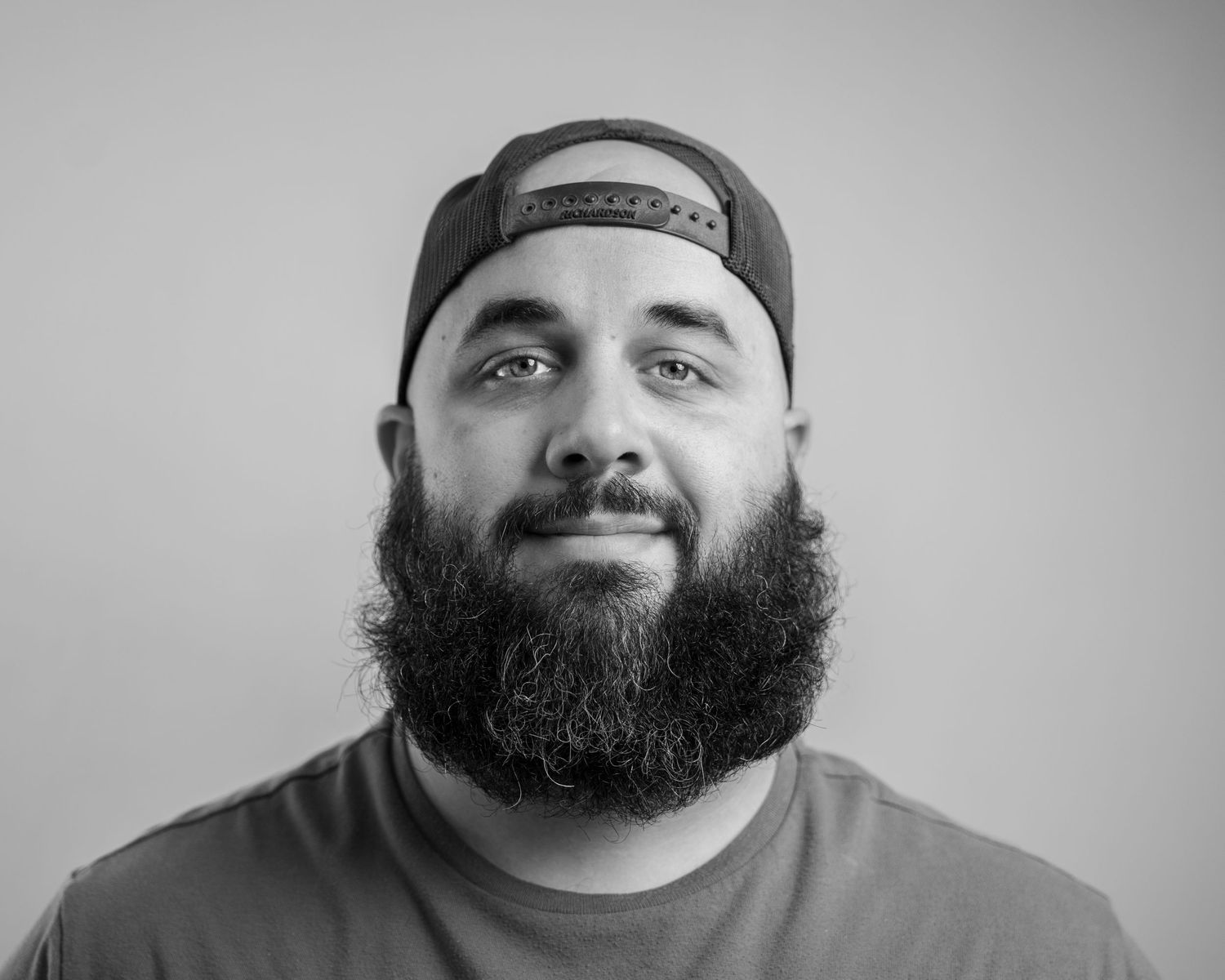 Black and white portrait shot against a simple gray background.