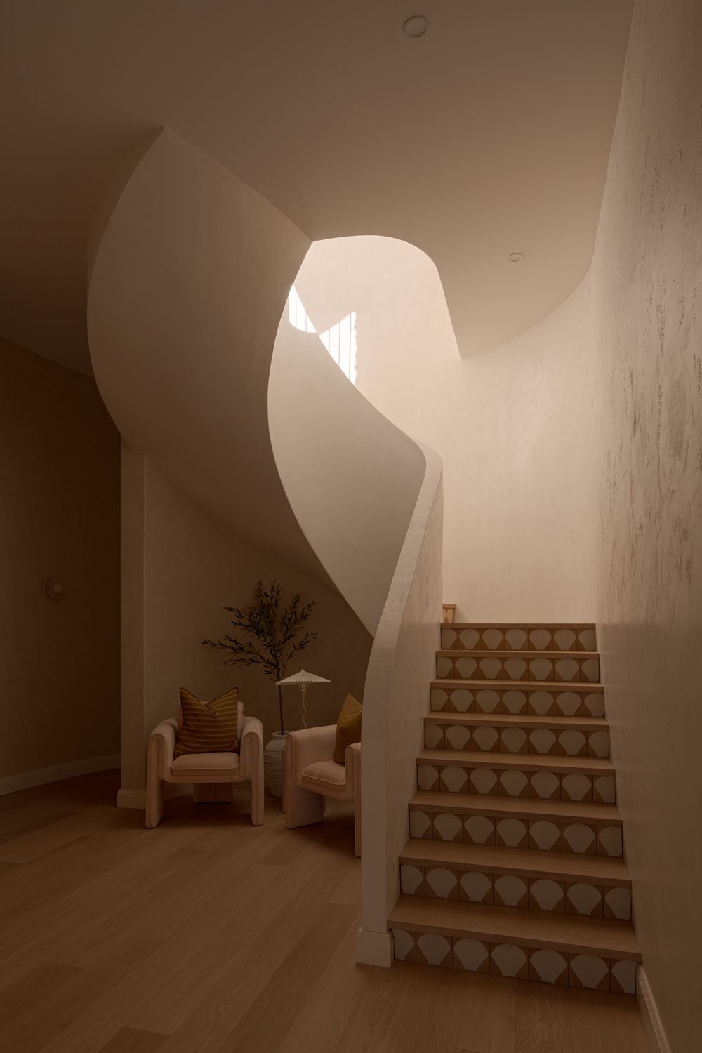 A curved staircase with decorative tiles leads upward in a minimalist white interior space with soft lighting.