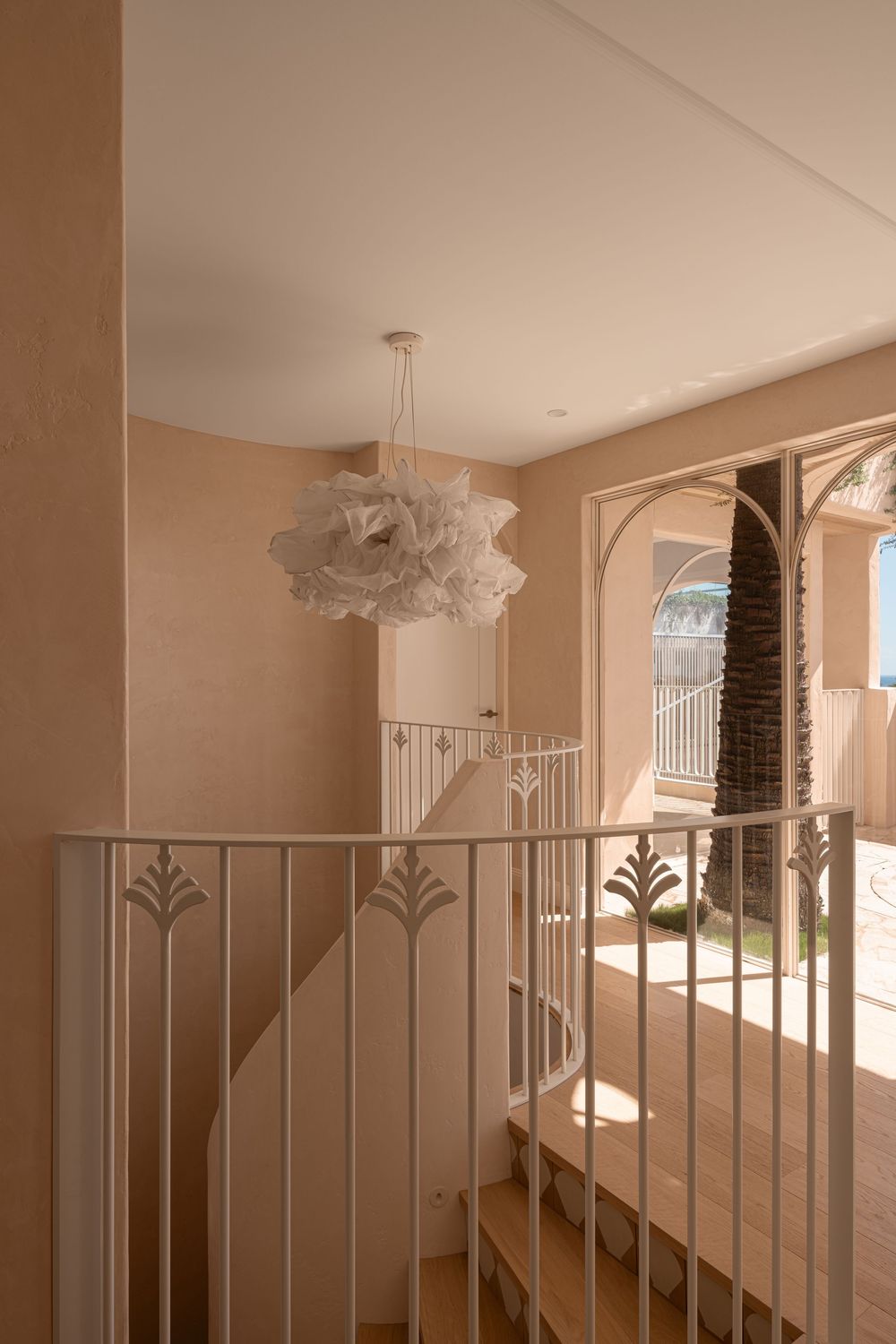 White decorative pendant light fixture with cloud-like ruffled texture hangs from ceiling in modern interior hallway.
