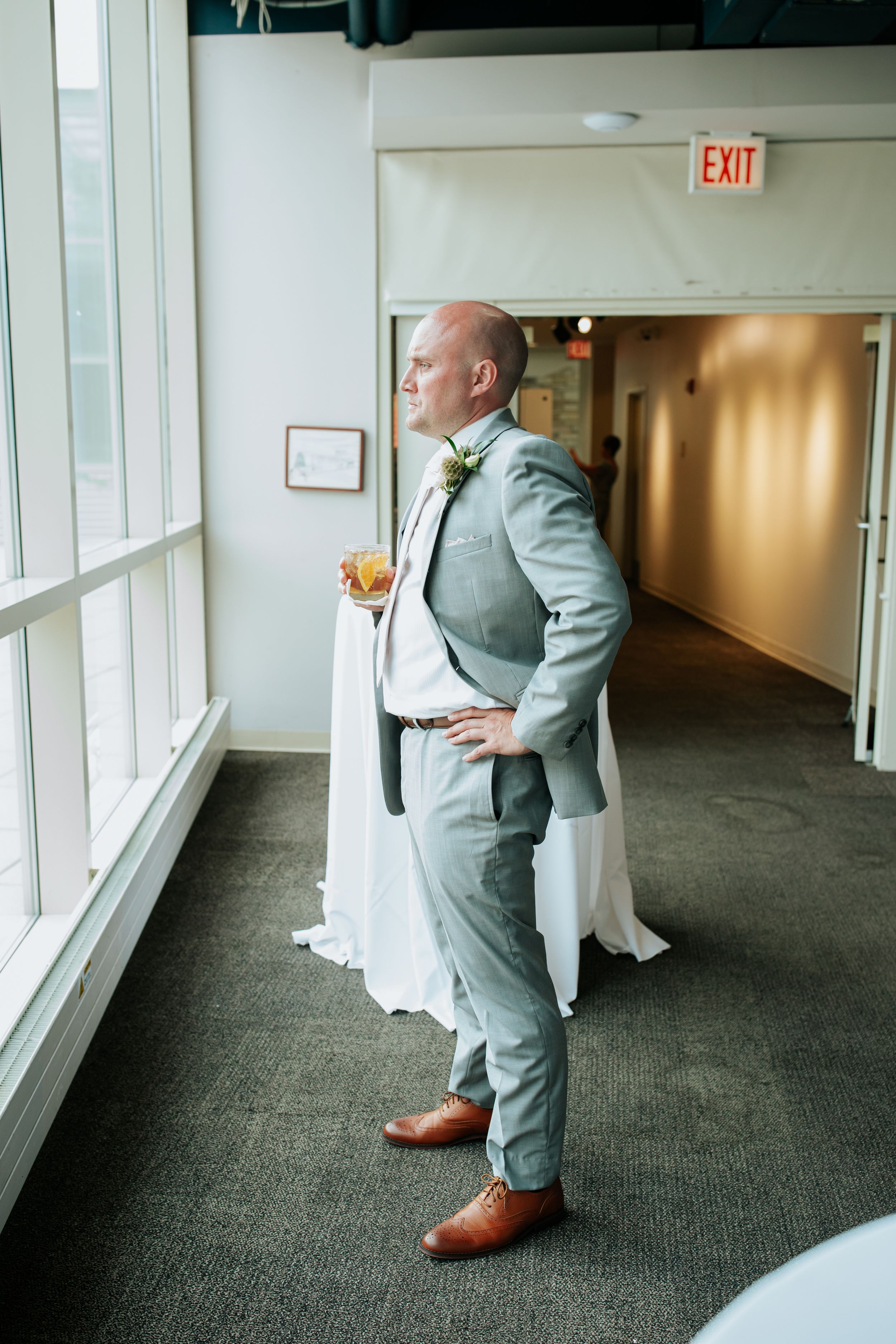 A sequence of photos showing a person in a light gray suit walking down a brightly lit office hallway.