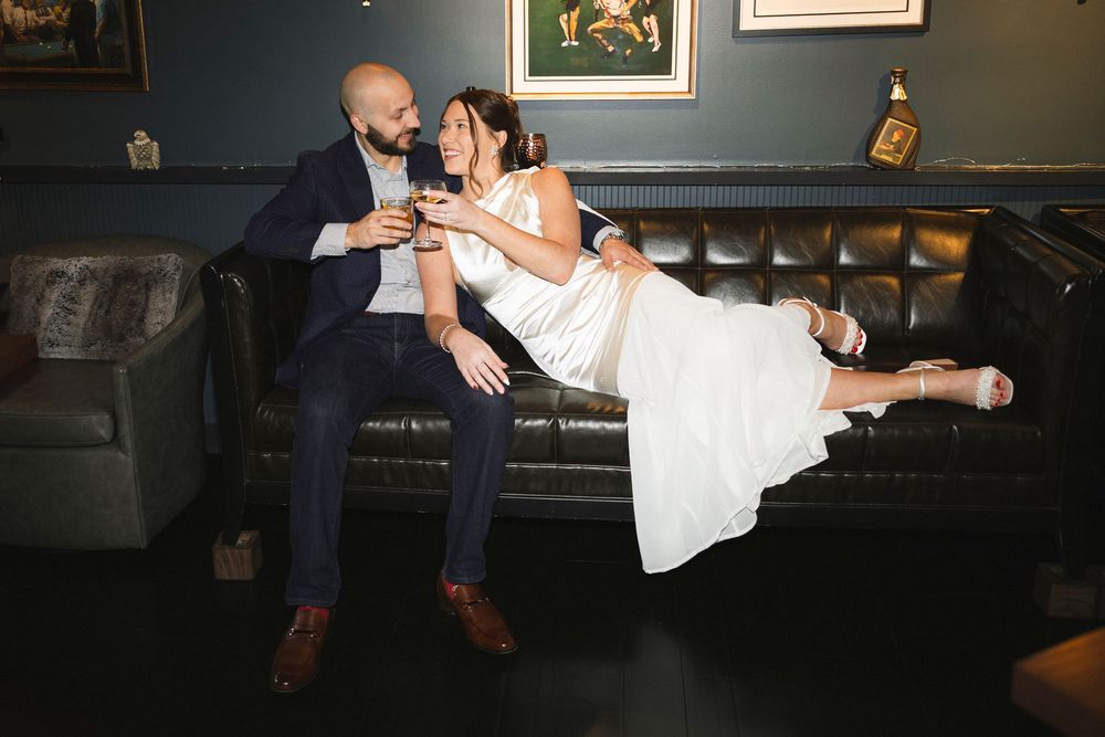 Romantic moment shared between a couple lounging on dark leather seating.