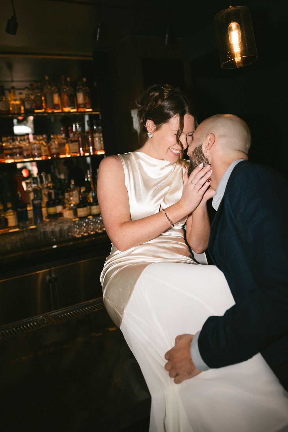 Romantic dance moment captured in a dimly lit bar setting.
