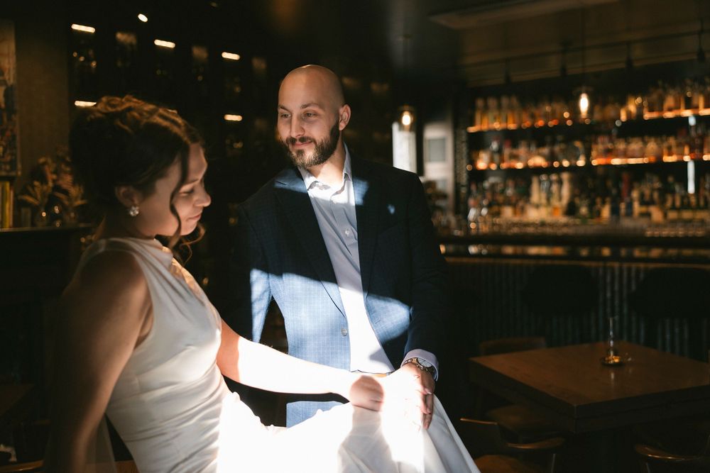 A couple in formal attire sharing a moment at a bar counter.
