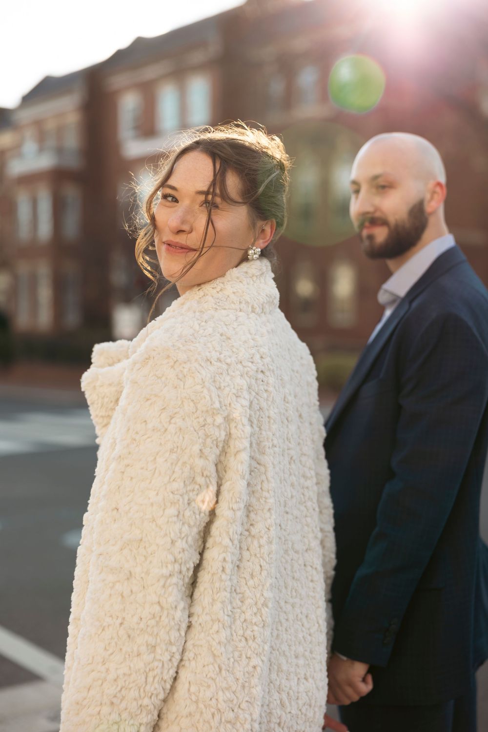 Sunlit outdoor portraits featuring a textured white coat against brick architecture.