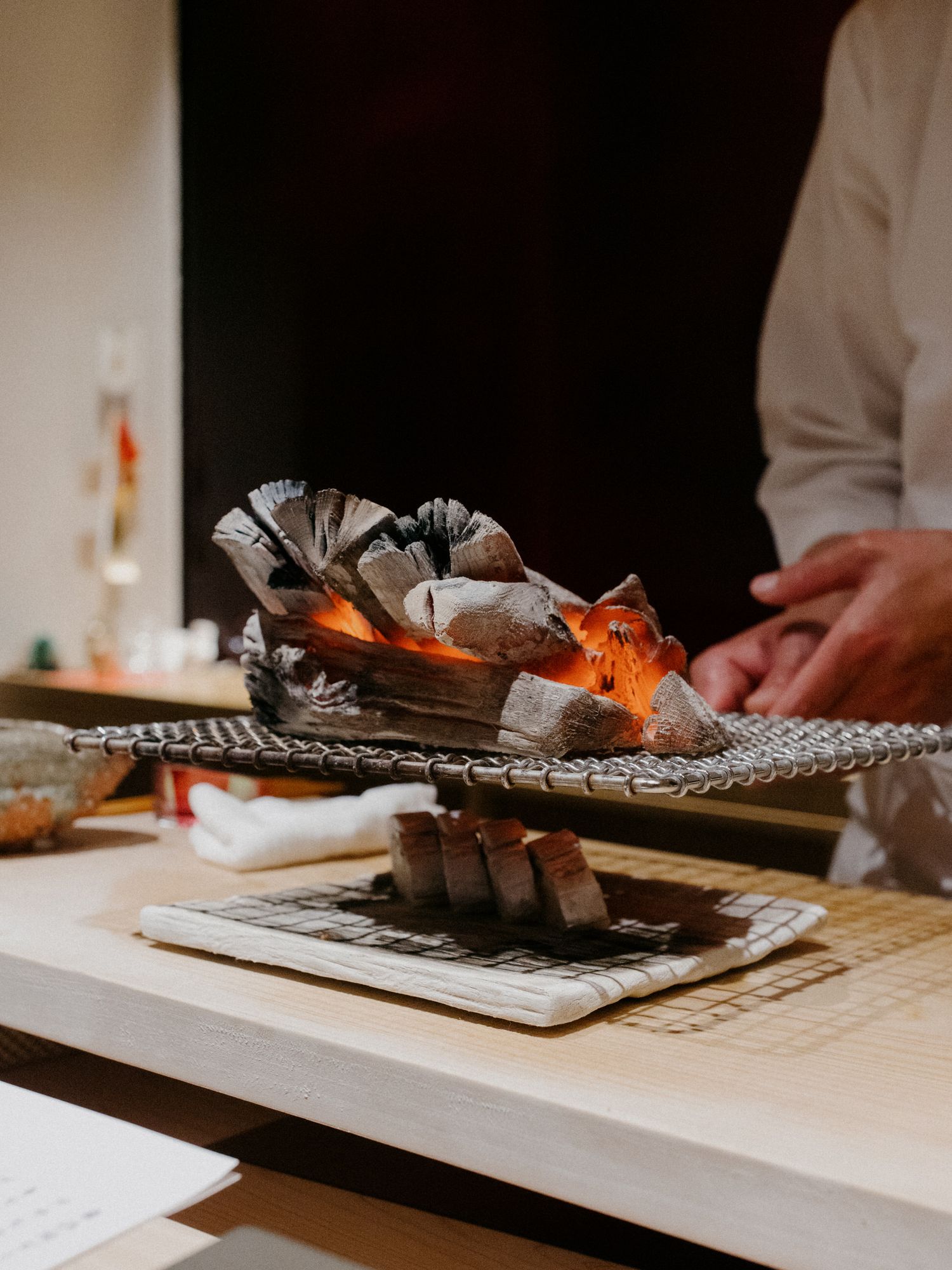 Fresh seafood being prepared with flame on an ornate serving plate.