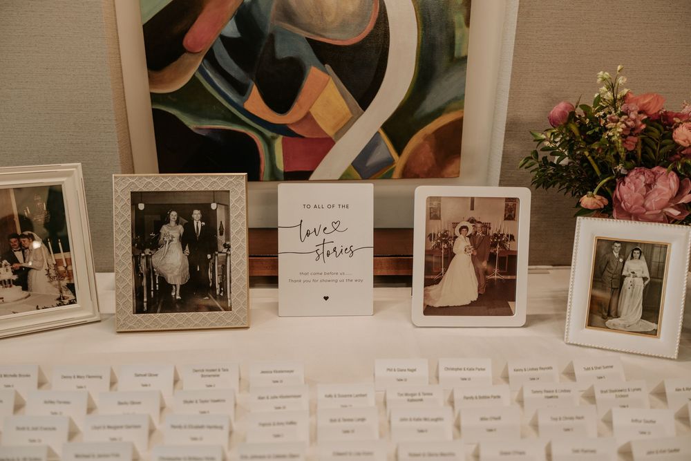 A rustic display of vintage photographs and polaroids arranged in a row against a beige wall.