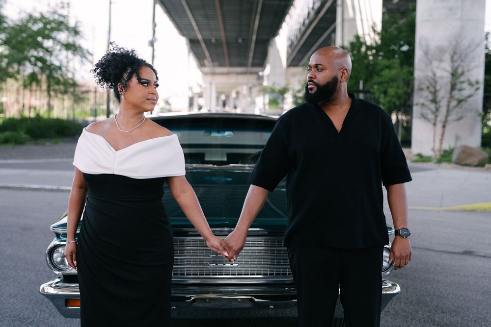 A couple shares tender moments together during an urban engagement photo session near parked cars and an overpass.