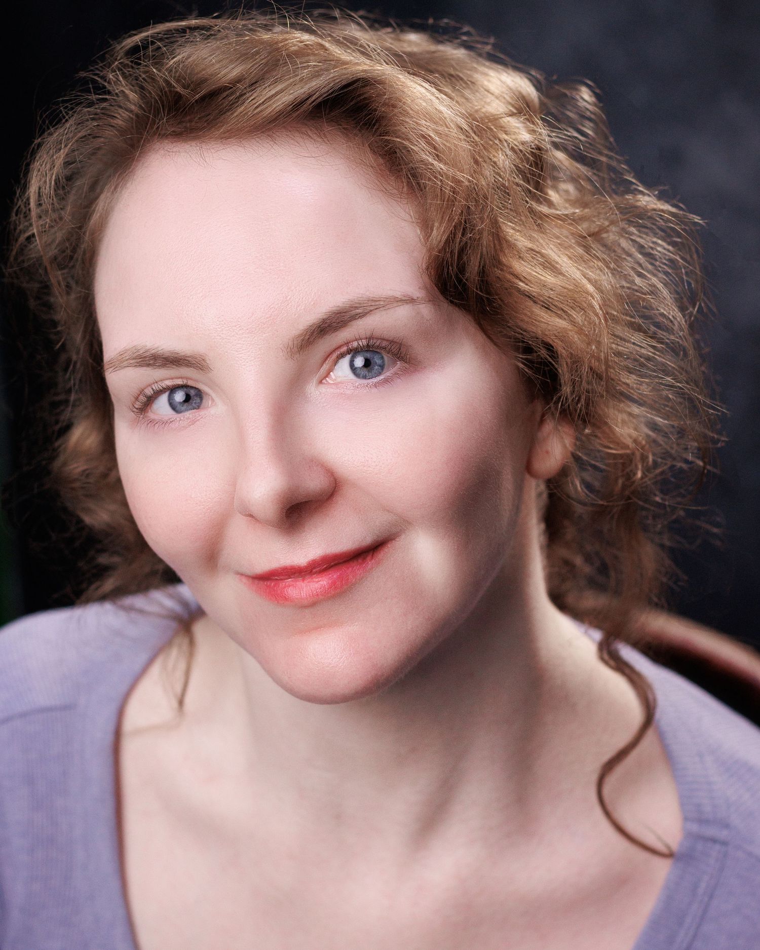 A woman with curly hair wearing a purple top poses expressively against a dark background through six headshots.
