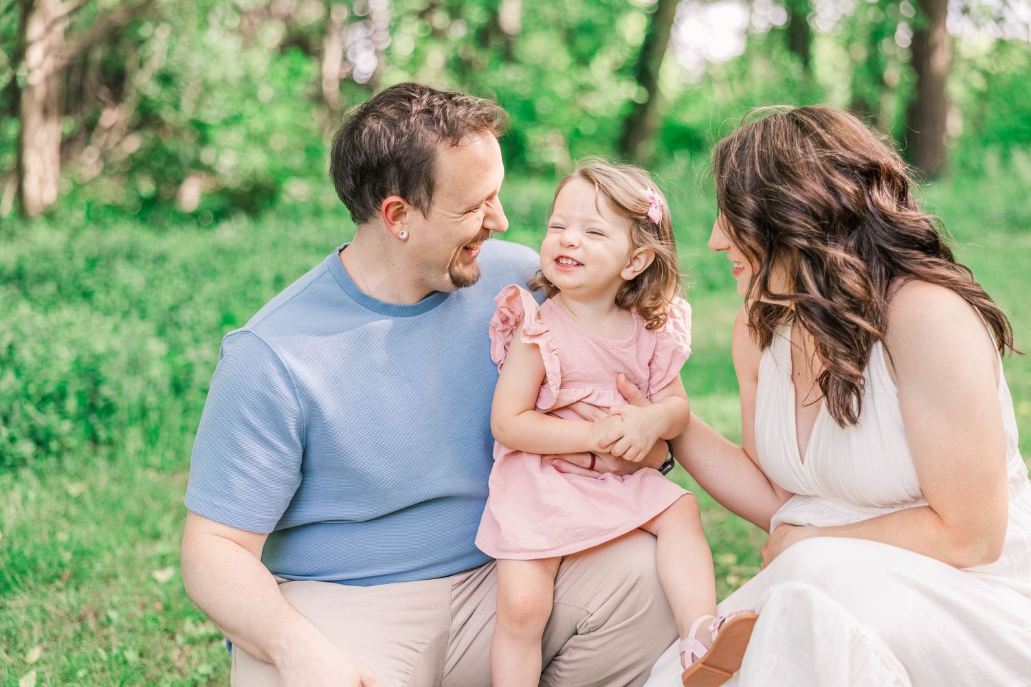 Happy family enjoying a playful moment together outdoors in a lush green park setting during Chattanooga family portrait session.