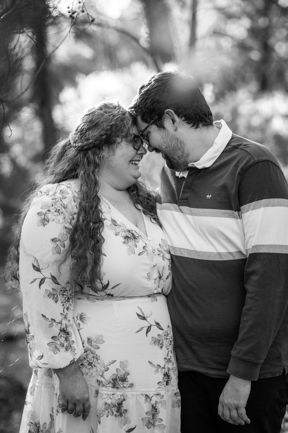 A romantic black and white portrait of a couple sharing an intimate moment together in nature.