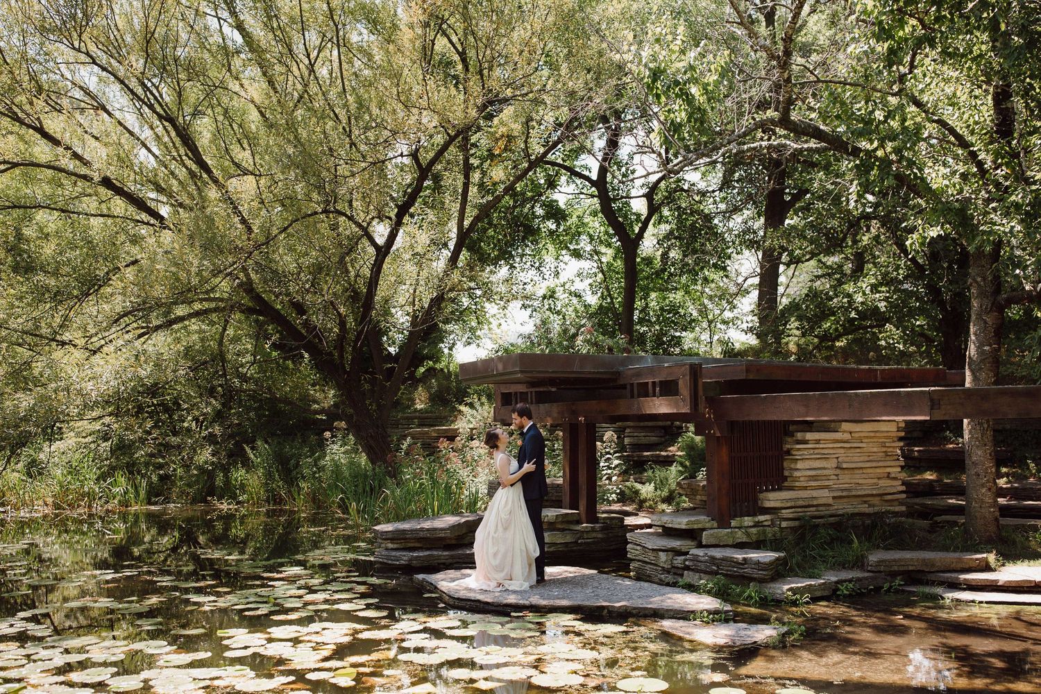 Scenic wooded outdoor wedding venue with natural stone and wooden benches.