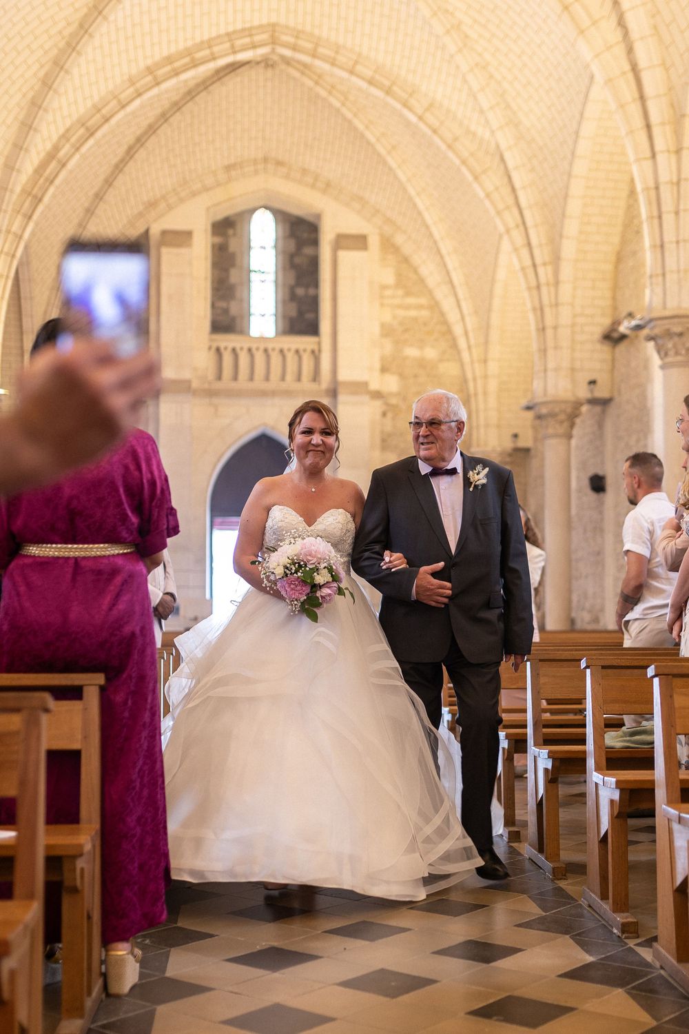 Entrée émouvante de la mariée au bras de son père à l'église de La Rochelle, reportage mariage plein de tendresse en Charente-Maritime.